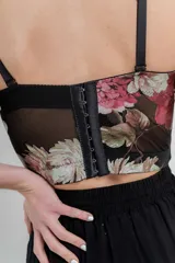 Top tipo corset con estampa floral, confeccionado en tul elástico con estructura interna y copas armadas. Breteles regulables y cierre con triple hilera de broches en espalda.