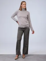 Polera de punto fino marca Nienty, color blanco, con cuello alto volcado y mangas largas con detalle de tajo en los puños.