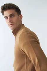 Buzo negro de algodón con cuello alto y medio cierre. Tiene logo bordado en el pecho y puños en las mangas.