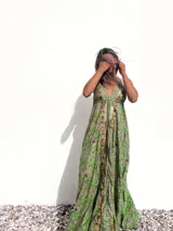 Vestido largo de seda verde con estampado paisley, escote halter y espalda descubierta.