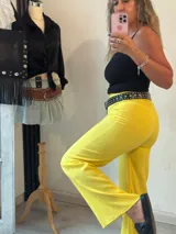 Pantalón amarillo de corte recto y tiro alto, con cierre frontal de botón y cremallera.