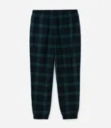 Pantalón de pijama de franela con estampa cuadrillé en tonos azul y verde. Tiene puños elásticos en los tobillos y cordón ajustable en la cintura.