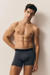Pack de tres calzoncillos tipo trunk de punto elástico de algodón en gris y negro, con cintura elástica con logo en blanco y costuras planas. Confeccionados con tecnología Lycra® Xtra Life™.