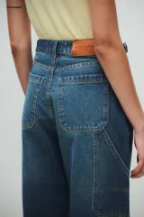Pantalón de jeans azul oscuro, de tiro medio y corte holgado, estilo carpintero.