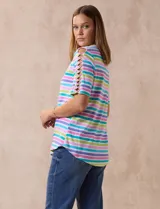 Remera de algodón a rayas horizontales en tonos rosa, celeste, verde y lila. Tiene cuello redondo y mangas cortas con detalle de entrelazado y aberturas en los hombros.