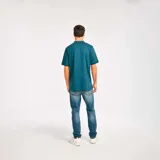 Remera tipo polo color petróleo con cuello de punto acanalado, puños de manga de punto plano y parche de silicona con el logo de Cat en el lado izquierdo del pecho.