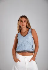 Blusa celeste de crochet con cuello redondo y ribete marrón.