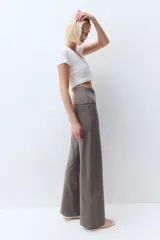 Pantalón de punto color gris topo, con cintura alta plegable y corte palazzo.
