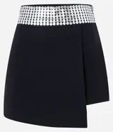 Minifalda negra cruzada de bengalina con cintura ancha de lentejuelas plateadas.