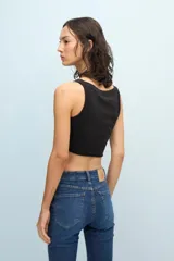 Musculosa corta negra de jersey pima de algodón peruano, de calce ajustado y escote en U. Presenta estampa metálica frontal con la palabra Ginebra.