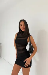 Minivestido negro de tela traslúcida con cuello alto y frunces.