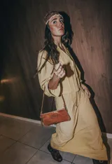 Cartera de mano tipo clutch, color marrón, confeccionada en cuero.