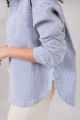 Sobrecamisa de denim con rayas azul y blanca, de corte suelto y manga larga.