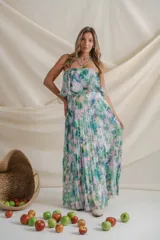 Vestido largo de gasa plisada con estampado floral en tonos verde, celeste, blanco y rosa. Diseño strapless con volado en el corsé, corte en la cintura y falda amplia.