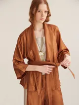 Kimono color cobre con textura brillante, mangas 3/4 y lazo para atar en la cintura.