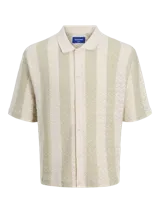 Polo de manga corta color crema con rayas verticales en relieve color verde claro. Tiene cuello clásico y cierre frontal con botones.