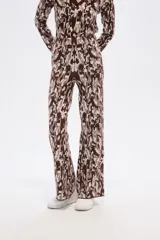 Pantalón de tejido de punto con tiro alto y calce ancho, presentando un estampado pixelado o camuflado en tonos marrón, beige y blanco.