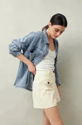 Short blanco de tiro alto con bolsillos delanteros con solapa y botones a la vista.