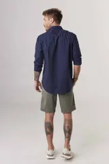 Camisa de hombre color crema, de corte clásico, con cuello abotonado y mangas largas.