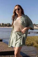 Camisa larga color beige con botones y cuello.