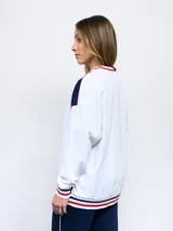 Buzo de felpa azul marino con mangas raglán rojas y detalles tricolor en puños, mangas y cuello. Incluye logo de Umbro bordado en el pecho y escudo del Club Nacional de Football.