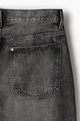 Pantalón de jean gris oscuro con efecto lavado, corte holgado, tiro bajo y cinco bolsillos.