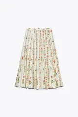 Falda midi de tiro medio confeccionada en hilatura de algodón. Tejido con tablas y estampado floral. Bajo acabado en vivo a contraste. Cierre lateral con cremallera oculta en costura.