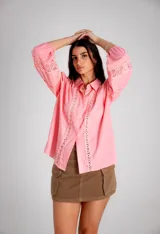 Camisa rosa con detalles de broderie en el frente y mangas globo.