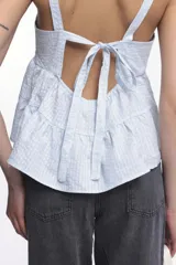 Top rosado con textura arrugada, breteles anchos y corte escalonado con volados.