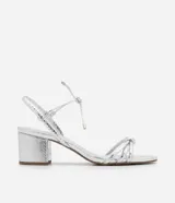 Sandalia plateada con textura crocco, taco bloque de 5 cm, tiras trenzadas en el empeine, cierre con lazo en el tobillo y puntera redonda.