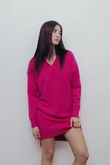 Vestido negro tejido con escote en V y corte recto. Largo hasta la rodilla con tajos laterales y detalle canalé en puños y ruedo.