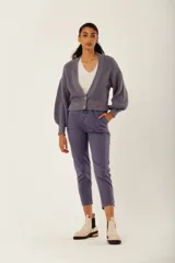 Cárdigan color marrón con tejido de punto acanalado, escote en V, cierre frontal con botones y mangas largas abullonadas.