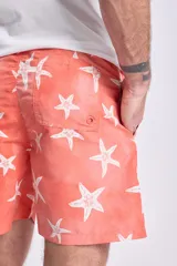 Short de baño color naranja con estampado de estrellas de mar blancas, cintura elástica con cordón ajustable.
