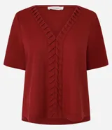 Blusa de manga corta color rojo oscuro (terracota/vino) con escote en V y detalle de pliegues verticales en el centro del frente.