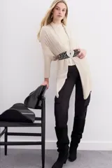 Cárdigan color beige de tejido suave, con calce relajado y largo irregular.