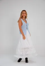 Falda larga blanca de estilo romántico, con volados en el ruedo y detalles de puntilla y encaje bordado.
