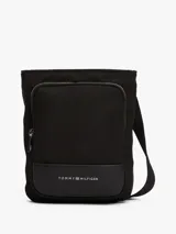 Bandolera Tommy Hilfiger negra de poliéster con acabado texturizado. Tiene correa ajustable, cierre de cremallera, bolsillo interior y exterior con cremallera, logo de Tommy Hilfiger grabado en bajo relieve en el interior y logo metálico en la parte delantera.