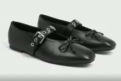 Balerinas color marrón con correa sobre el empeine con hebilla metálica y detalle de moño en la punta.