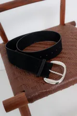 Cinturón negro de gamuza sintética con hebilla metálica plateada.