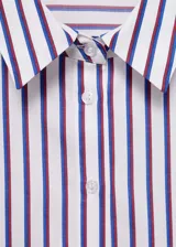 Camisa crop de rayas verticales blancas y azules, con cuello camisero, cierre frontal con botones, mangas largas con puños abotonados y corte regular.