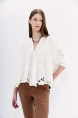 Blusa blanca de viscosa con escote en V, mangas 3/4 con detalle de encaje y pinzas verticales en el frente.