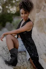 Chaleco largo de crochet calado color negro, sin mangas y con botones frontales.