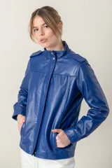 Campera roja de cuero ovino italiano, con charreteras en los hombros, bolsillos laterales, broches ocultos en el frente y broches a la vista en cuello y puños.