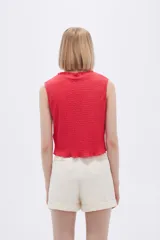 Musculosa negra con textura arrugada, cuello redondo y corte ajustado.