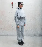 Buzo hoodie gris de tela deportiva con faja estilo corset y detalle de puño en manga.