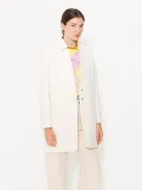 Saco color crema confeccionado en algodón, con bolsillos ojal, hombreras y aplique Groovy en el cuello.