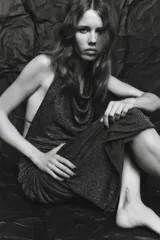 Vestido largo de fiesta confeccionado con hilo metalizado color marrón. Tiene cuello halter con lazada, escote drapeado, espalda descubierta con tira ajustable y cierre lateral con cremallera oculta.