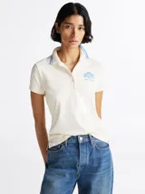 Chomba Tommy Hilfiger color crema, de corte slim fit, con cuello polo ribeteado en azul y logo bordado en el pecho.