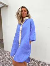 Vestido camisero celeste de lino con cuello mao, corte recto, mangas tres cuartos y cierre frontal con botones.