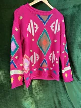 Sweater tejido de hilo color crema con diseño geométrico en rojo, azul, amarillo y verde.